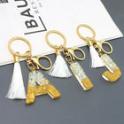 Llaveros Charms Personalizados con Iniciales - Letras Doradas y Borla Blanca para Bolsos