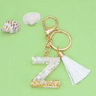 Llaveros Charms Personalizados con Iniciales - Letras Doradas y Borla Blanca para Bolsos
