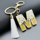 Llaveros Charms Personalizados con Iniciales - Letras Doradas y Borla Blanca para Bolsos