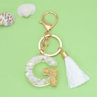 Llaveros Charms Personalizados con Iniciales - Letras Doradas y Borla Blanca para Bolsos