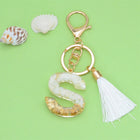 Llaveros Charms Personalizados con Iniciales - Letras Doradas y Borla Blanca para Bolsos