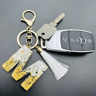 Llaveros Charms Personalizados con Iniciales - Letras Doradas y Borla Blanca para Bolsos